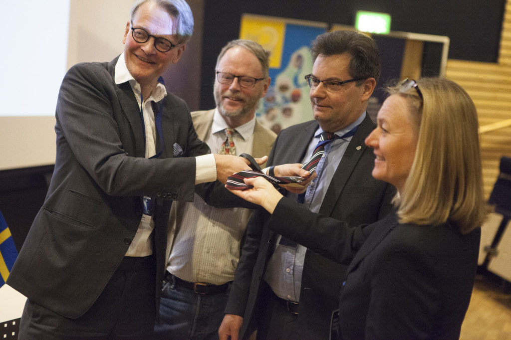 Carl Rosén från Näringsdepartementet inviger företagsklustret genom att klippa av slipsarna för Olle Persson, ansvarig för klustret norra noden, Göran Berlemo, VD för Aerospace Cluster Sweden. Till höger i bilden är Johanna Bergström-Roos, arrangör av Space Innovation Forum. Att klippa slipsar är en gammal rymdtradition från raketbasen Esrange i Kiruna som symboliserar en mindre formell approach där fokus läggs på arbete och nytta i stället för långa möten.